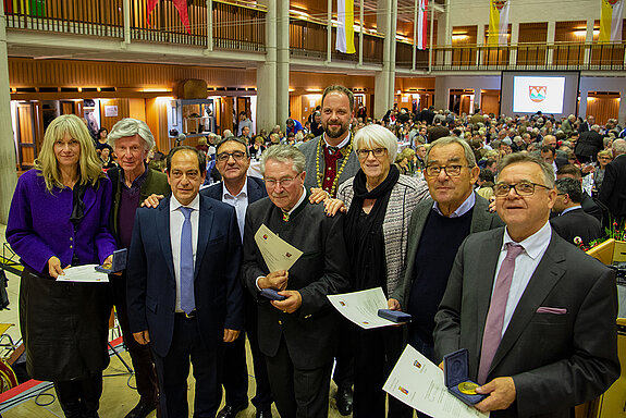 Große Ehre! Arpajon verleiht die Stadtmedaille an fünf Freisinger Persönlichkeiten: Birgit Mooser-Niefanger, Claude Brun, Christan Béraud, Antonio De Almeida, Hubert Hierl, OB Tobias Eschenbacher, Martine Braquet, Helmut Weinzierl und Rupert Widmann. (Foto: Stadt Freising) 