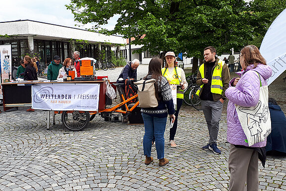 Ein zum Kaffeestand umgebautes Fahrrad und mehrere Menschen darum herum