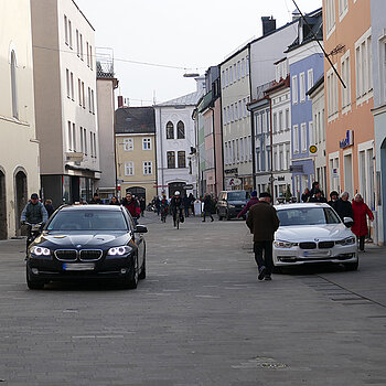 Blick in die Untere Hauptstraße mit Fußgängern und fahrenden sowie parkenden Autos