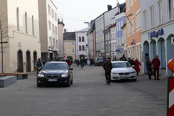 Blick in die Untere Hauptstraße mit Fußgängern und fahrenden sowie parkenden Autos