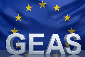 GEAS-Schriftzug vor EU-Flagge. Bild erstellt mit Canva AI Eine blaue EU-Fahne mit den Sternen, die sich etwas wölbt. Davor der GEAS-Schriftzug