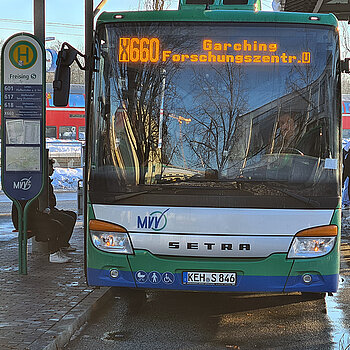 Bus an einer Bushaltestelle frontal aufgenommen. 