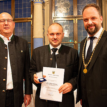 OB Tobias Eschenbacher zeichnet Martin Heilmeier (Mitte) aus. (Foto: Stadt Freising)