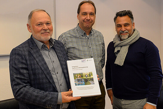 Den Sportentwicklungsplan in der Hand, die Umsetzung im Blick: Bürgermeister Hans Hölzl, Referatsleiter Karl-Heinz Wimmer und Sebastian Wanzke, Vorsitzender des Stadtverbands für Sport (v.l.). (Foto: Stadt Freising)