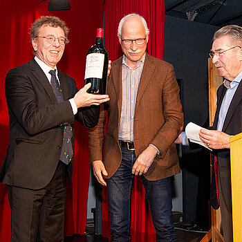 Vorfreude auf den guten Tropfen: Martin Keeser mit der Riesenflasche Rotwein, überreicht von Jürgen Maguhn (Mitte) und Kulturreferent Hubert Hierl. 
