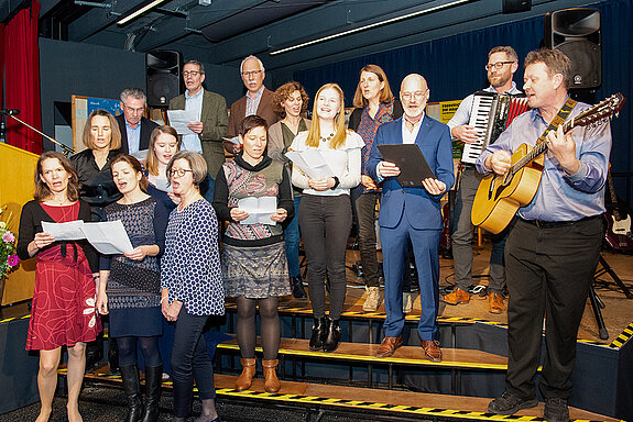 Auch die Musikschul-Beiräte erobern die Bühne: als lauthals schmetternder Chor mit Bob Dylans „My Back Pages“.