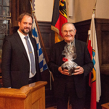 Posieren für die Medien: OB Tobias Eschenbacher (links) und Weihbischof Bernhard Haßlberger mit seinem Geburtstagsgeschenk, einem Freisinger Bären. (Foto: Stadt Freising) 