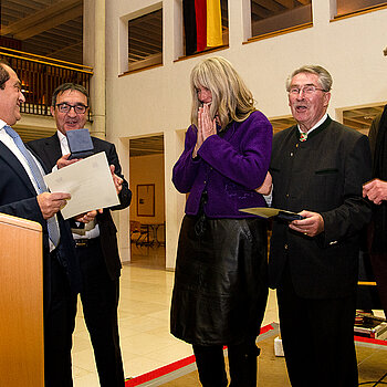 Gerührt nimmt Birgit Mooser-Niefanger (Mitte) die Stadtmedaille in Empfang. Sie war erstmals bei einem Schüler*innen-Austausch vor 35 Jahren in Arpajon. (Foto: Stadt Freising)