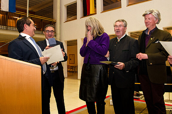 Gerührt nimmt Birgit Mooser-Niefanger (Mitte) die Stadtmedaille in Empfang. Sie war erstmals bei einem Schüler*innen-Austausch vor 35 Jahren in Arpajon. (Foto: Stadt Freising)