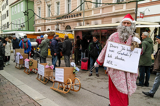 Als Nikolaus verkleideter Aktivist zieht Schlitten mit Forderungen zum Lieferkettengesetz.
