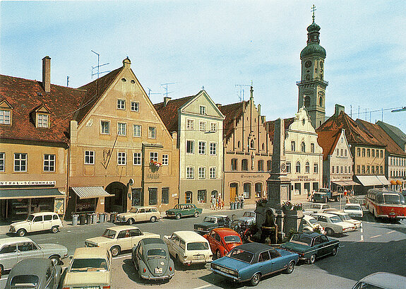 Als Autoparkplatz diente der Bereich ums das Kriegerdenkmal nach der Umgestaltung in den 1950-er und 1960-er Jahren, wie eine um 1965 entstandene Aufnahme zeigt. (Postkartensammlung Stadtarchiv Freising)