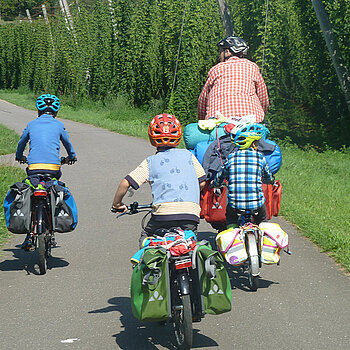 eine Familie fährt mit Gepäck auf dem Rad in den Urlaub