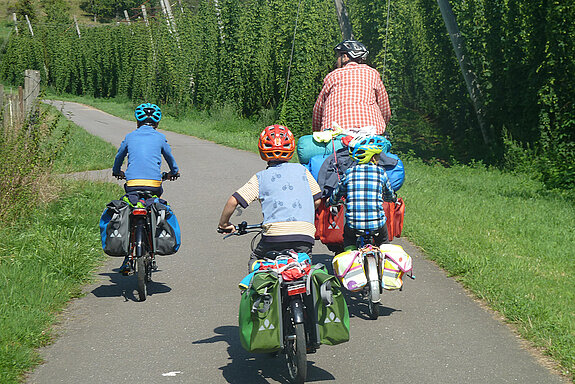 eine Familie fährt mit Gepäck auf dem Rad in den Urlaub