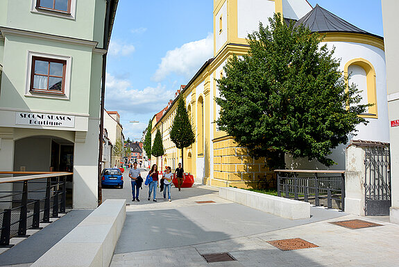 Fröhliche Farbtupfer: Die Heiliggeistgasse schmücken seit Montag, 21. August 2017, sieben Bäume in knallbunten Großkübeln. (Foto: Stadt Freising)