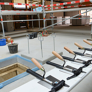 Es ist angerichtet: Kelle und Hammer liegen bereit, rechts die Zeitkapsel, die im vorbereiteten Schacht  eingemauert wird. (Foto: Stadt Freising)   