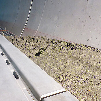 Tunnelbau Westtangente Freising: Ausbauarbeiten im Bergmännischen Tunnel mit Schlitzrinne und Kabelleerrohren im Bereich der Notgehwege