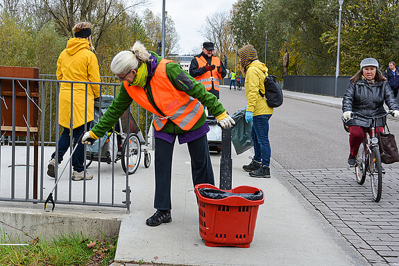 Dank praktischer Greifarme ist das Müllsammeln komfortabel und effektiv. Hier wird die Korbinianbrücke von Kleinmüll befreit. (Foto: Stadt Freising)