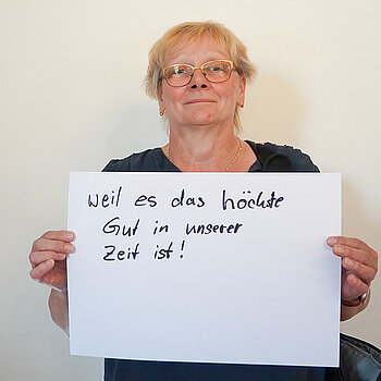 Stadtratsmitglied Johanna Hiergeist. Foto: Stadt Freising Eine Frau in einem blauen T-Shirt zeigt ein Schild mit der Aufschrift: "weil es das höchste Gut in unserer Zeit ist!
