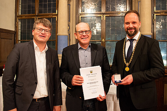 OB Tobias Eschenbacher zeichnet Nikolaus Stommel (Mitte) aus. (Foto: Stadt Freising)