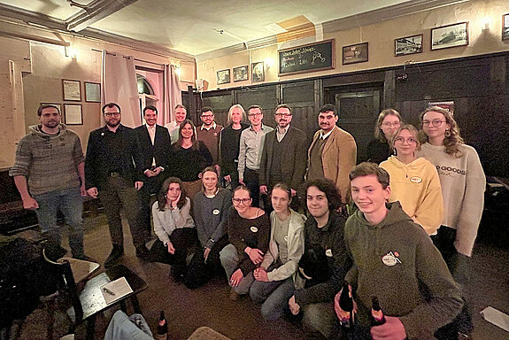 Gruppenbild in einer dunkel get&auml;felten Wirtsstube