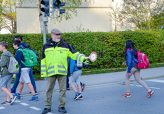 Ehrenamtliche Helfer*innen wie  Norbert May an Rotkreusztraße unterstützen Kinder dabei, sicher zur Schule und wieder nach Hause zu kommen. (Foto: Stadt Freising)