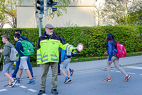 Ehrenamtliche Helfer*innen wie  Norbert May an Rotkreusztraße unterstützen Kinder dabei, sicher zur Schule und wieder nach Hause zu kommen. (Foto: Stadt Freising)