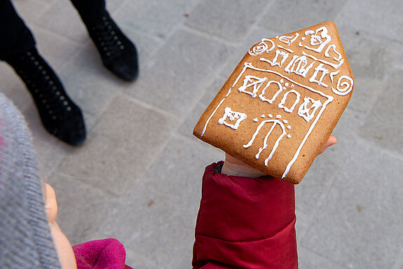 Stolz zeigt ein Mädchen sein Ergebnis der Lebkuchen-Bemal-Aktion. (Foto: Stadt Freising)