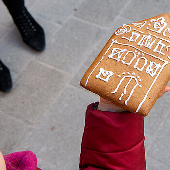 Stolz zeigt ein Mädchen sein Ergebnis der Lebkuchen-Bemal-Aktion. (Foto: Stadt Freising)