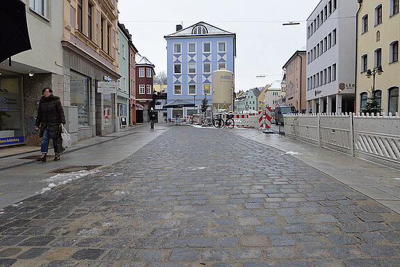 Der Abschnitt von der "Zinnernen Kanne" (blaues Haus im Hintergrund) Richtung Hirtlederergasse ist bereits fertiggestellt. Die kleinen, dunklen Pflastersteine markieren den hier abgedeckten Bachlauf. (Foto: Stadt Freising)