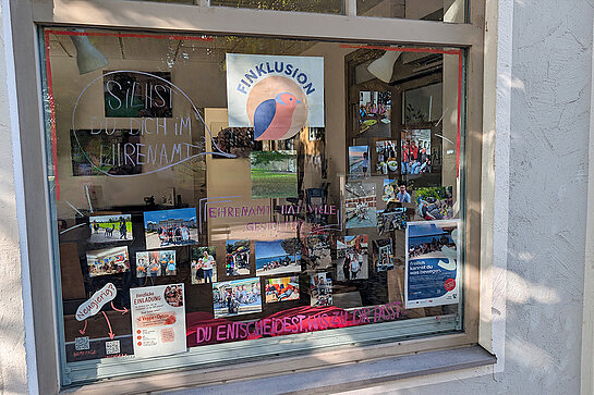 Die Lebenshilfe zeigt im Fenster der "Finklusion" viele Gesichter des Engagements. Foto: Stadt Freising Ein Schaufenster mit vielen Fotos und einem Spiegel "siehst Du Dich im Ehrenamt?" und