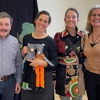 Drei Frauen (eien davon mit 2 Handpuppen) und ein Mann lachen in die Kamera