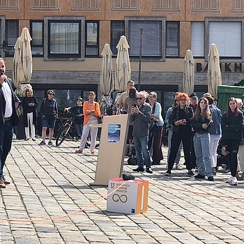 Oberbürgermeister Eschenbacher sprechend vor Publikum auf dem sonnigen Marienplatz.