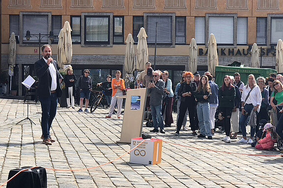Oberbürgermeister Eschenbacher sprechend vor Publikum auf dem sonnigen Marienplatz.