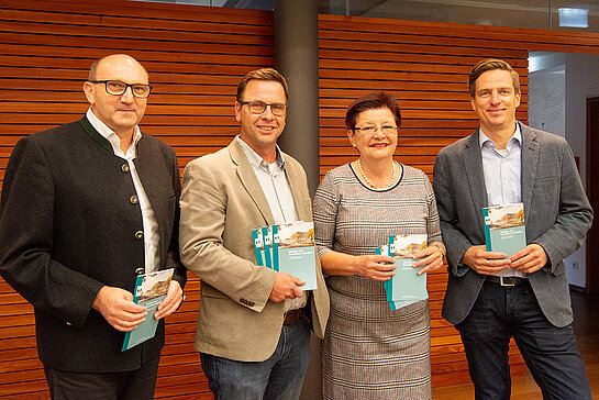 Architekt Anton Rudolph, Projektleiter Rudolf Striegl, Bürgermeisterin Eva Bönig und Hochbauamtsleiter Robert Naujokat (v.l.) präsentieren den Infoflyer für die Anwohner*innen. (Foto: Stadt Freising)