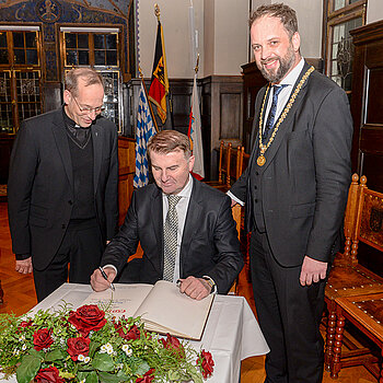 Eintrag ins Goldene Buch der Stadt (v.l.): Christian Hartl (Renovabis), Botschafter But und OB Eschenbacher. (Foto: Stadt Freising) 