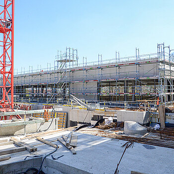 Heute noch Baulagerfläche, bald schon das Pausenhof: das große Areal zwischen Schulen und der (hinten im Bild) Sporthalle. (Foto April 2021: Stadt Freising) 