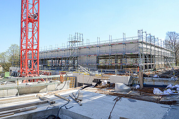 Heute noch Baulagerfläche, bald schon das Pausenhof: das große Areal zwischen Schulen und der (hinten im Bild) Sporthalle. (Foto April 2021: Stadt Freising) 