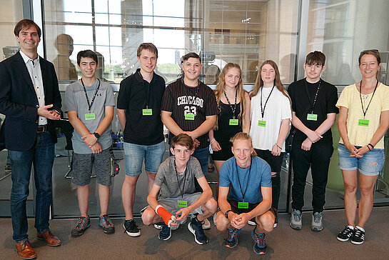 Gruppenbild mit Schüler*innen, Lehrerin und Andreas Mehltretter im schwarzen Sakko.