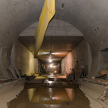 Durchgehend offen: Das Bild zeigt den Übergang von der bergmännischen Bauweise des Tunnels (mit dem Eiprofil) und der Deckelbauweise im Hintergrund. Der noch nicht abgenommene Belüftungsschlauch ist nicht mehr in Betrieb, da die natürliche Durchlüftung des Tunnels bereits funktioniert. (Foto: Stadt Freising)