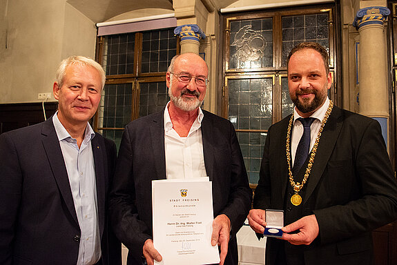 OB Tobias Eschenbacher zeichnet Walter Flad (Mitte) aus. (Foto: Stadt Freising)