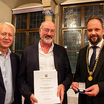 OB Tobias Eschenbacher zeichnet Walter Flad (Mitte) aus. (Foto: Stadt Freising)