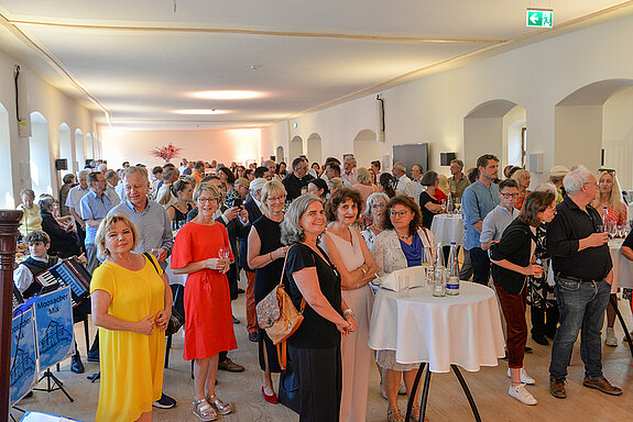 Das Foto zeigt das Foyer im zweiten Stock des Asamgebäudes mit vielen Menschen.