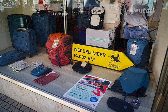 Taschen und Koffer, darunter ein gelber Wegweiser zum Weddelmeer und ein Plakat das für Engagement wirbt.